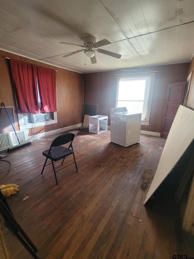 interior space with ceiling fan, dark hardwood / wood-style floors, washer / dryer, and wooden walls