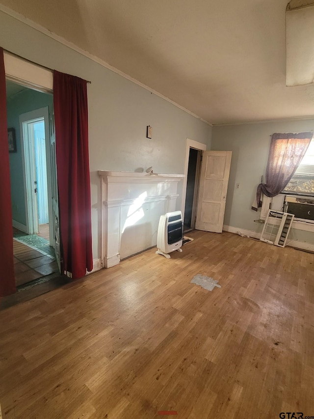 unfurnished living room featuring heating unit, cooling unit, and hardwood / wood-style flooring