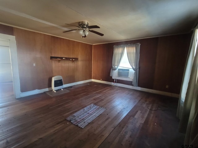 unfurnished room with ceiling fan, dark hardwood / wood-style floors, heating unit, wood walls, and cooling unit