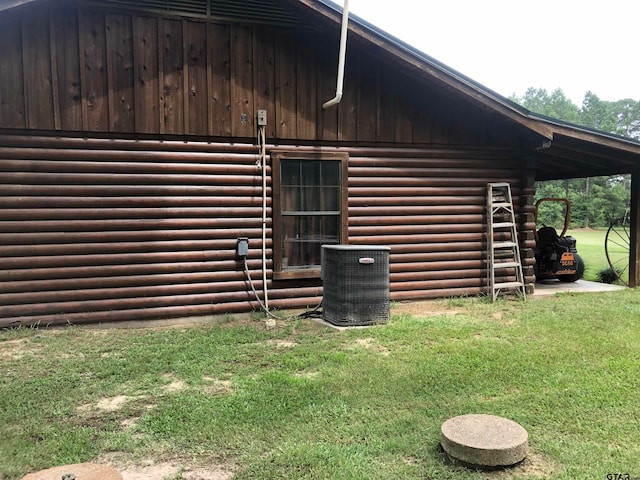 view of side of property with central AC and a yard