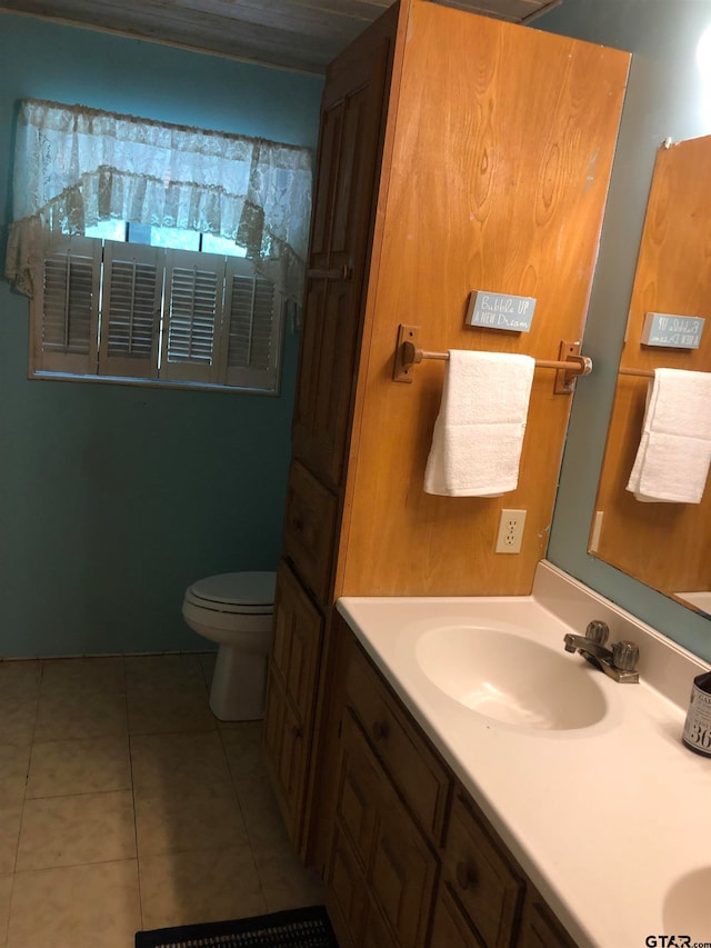 bathroom with toilet, vanity, and tile patterned floors