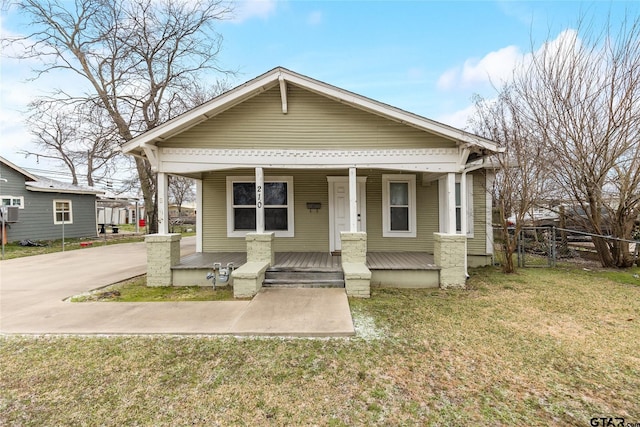 bungalow-style house with a porch, a front yard, and fence