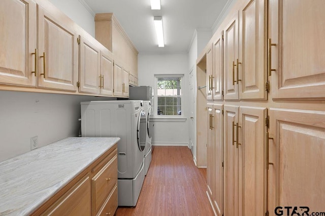 1701 Devonshire Dr, Tyler, TX 75703 - washroom featuring washing machine and dryer, cabinet space, light wood-style flooring, and crown molding