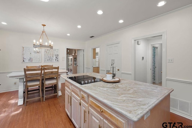 1701 Devonshire Dr, Tyler, TX 75703 - kitchen featuring black electric cooktop, light wood-type flooring, recessed lighting, ornamental molding, and pendant lighting