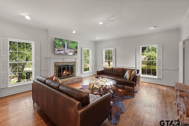 1701 Devonshire Dr, Tyler, TX 75703 - living room featuring crown molding, a glass covered fireplace, wood finished floors, recessed lighting, and a decorative wall