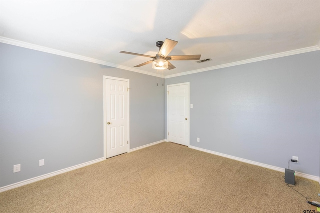 empty room with light colored carpet, a ceiling fan, baseboards, visible vents, and ornamental molding