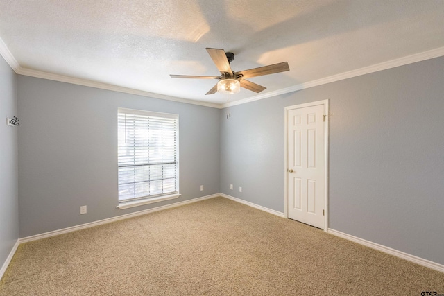 carpeted empty room featuring baseboards, ceiling fan, ornamental molding, and a textured ceiling