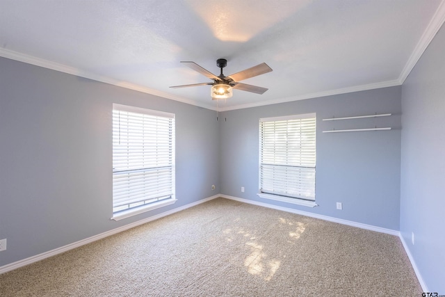 carpeted empty room featuring a ceiling fan, crown molding, and baseboards