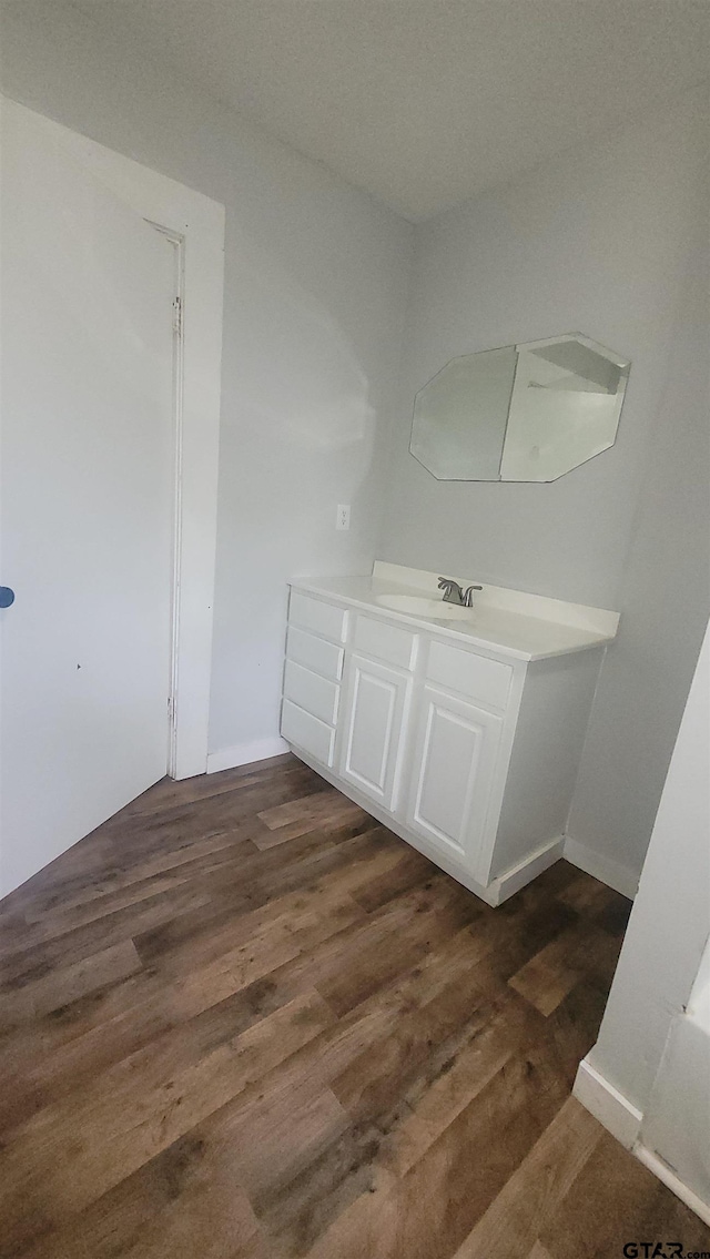 bathroom with baseboards, wood finished floors, and vanity