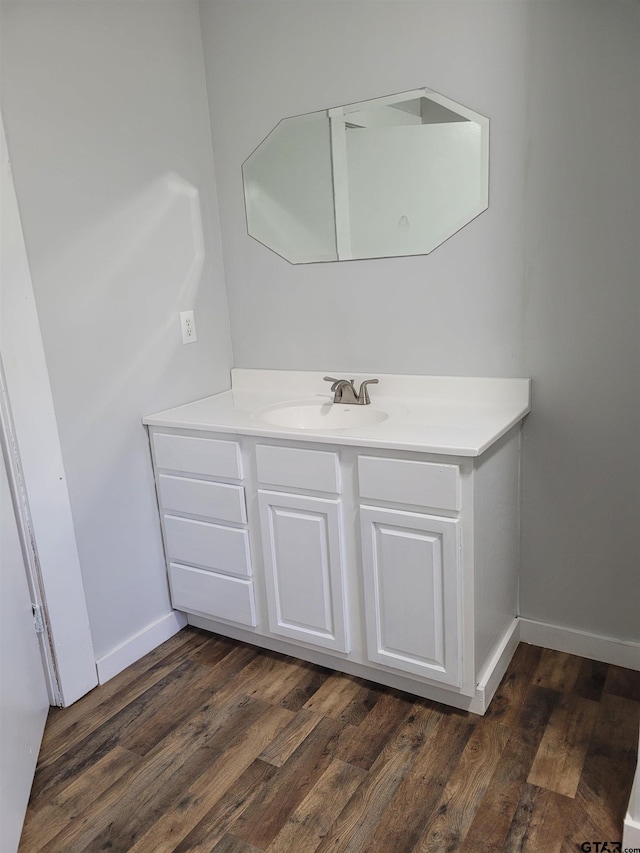 bathroom with vanity, baseboards, and wood finished floors