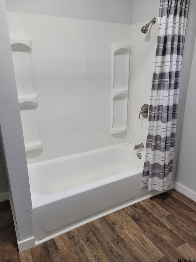 full bathroom featuring wood finished floors and shower / tub combo