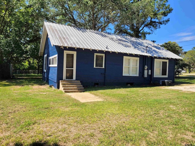 ranch-style home featuring central AC unit, metal roof, a front yard, and entry steps