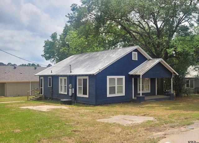 ranch-style house with metal roof, a porch, and a front lawn