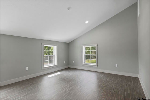 empty room with dark hardwood / wood-style floors and lofted ceiling