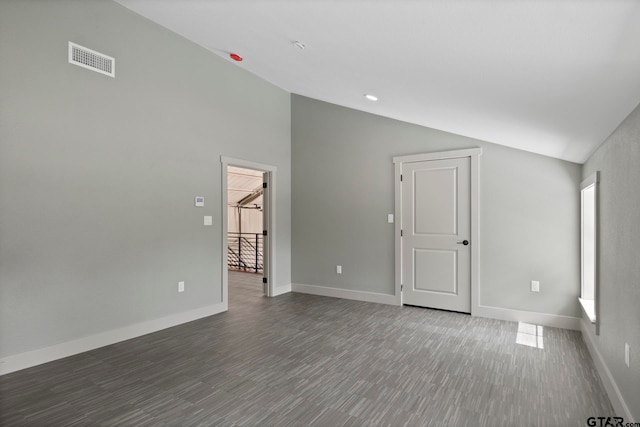 spare room featuring lofted ceiling and dark hardwood / wood-style floors