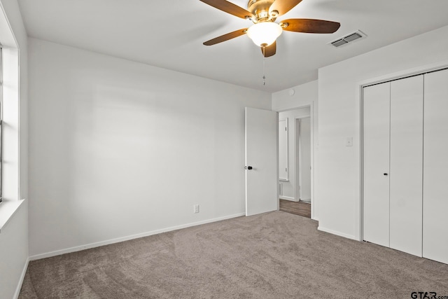 unfurnished bedroom with carpet flooring, ceiling fan, and a closet