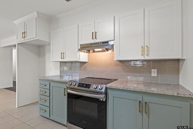 kitchen featuring electric range, light stone countertops, light tile patterned floors, backsplash, and white cabinets