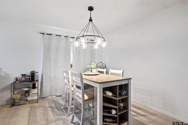 tiled dining room with an inviting chandelier