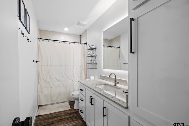 bathroom with hardwood / wood-style floors, vanity, and toilet