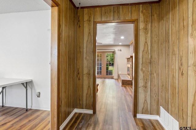 314 Cedar St, Mount Pleasant, TX 75455 - hall with wood finished floors, wooden walls, visible vents, and a textured ceiling