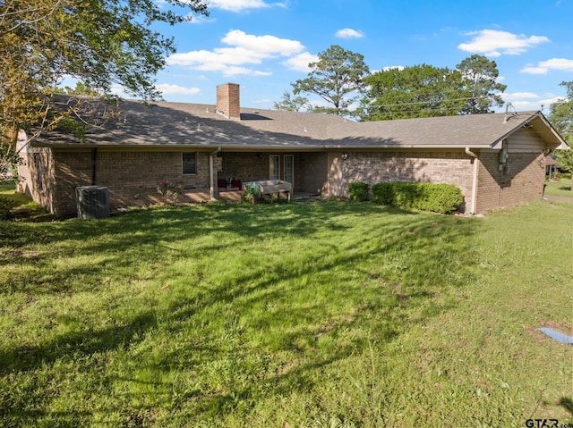 314 Cedar St, Mount Pleasant, TX 75455 - rear view of house with brick siding, a yard, and a chimney