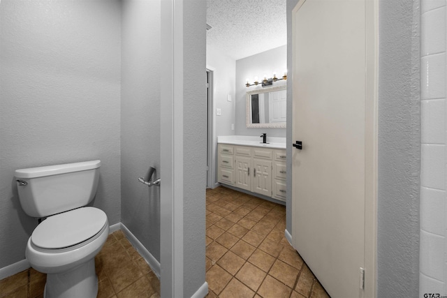 4715 Edinburgh Dr, Tyler, TX 75703 - bathroom with toilet, vanity, a textured ceiling, baseboards, and tile patterned floors