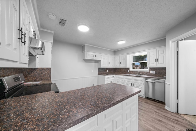 4715 Edinburgh Dr, Tyler, TX 75703 - kitchen with ventilation hood, stainless steel appliances, a sink, a textured ceiling, and wood finished floors