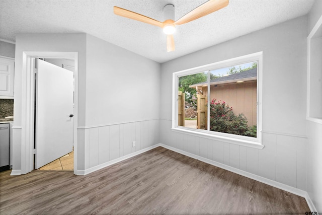 4715 Edinburgh Dr, Tyler, TX 75703 - empty room with wood finished floors, a textured ceiling, wainscoting, and ceiling fan