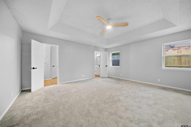 4715 Edinburgh Dr, Tyler, TX 75703 - spare room featuring a raised ceiling, a ceiling fan, a textured ceiling, carpet flooring, and baseboards