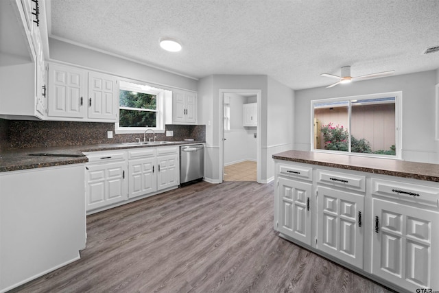 4715 Edinburgh Dr, Tyler, TX 75703 - kitchen with dishwasher, a sink, dark countertops, white cabinetry, and a textured ceiling