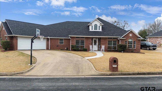 view of front of house featuring a garage, concrete driveway, brick siding, and a front lawn