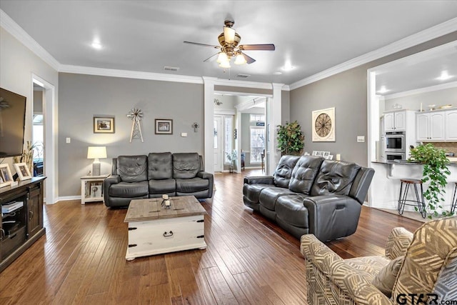 living area with dark wood-style floors, visible vents, crown molding, and a ceiling fan