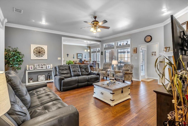 living room featuring visible vents, crown molding, and hardwood / wood-style floors