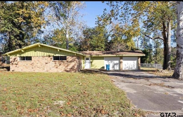 single story home with a garage and a front yard