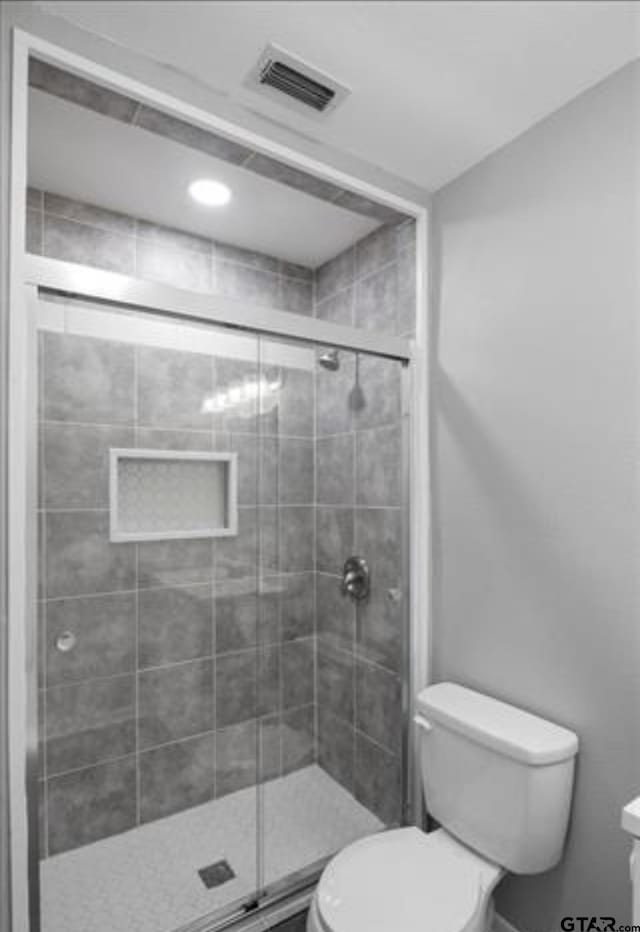 bathroom with toilet and walk in shower