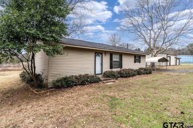 view of front of house with a carport and a front lawn