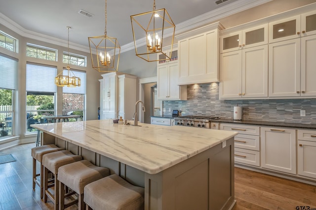 kitchen featuring dark stone counters, a wealth of natural light, pendant lighting, and light wood-type flooring