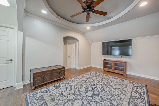 living room with ceiling fan, hardwood / wood-style floors, crown molding, and vaulted ceiling