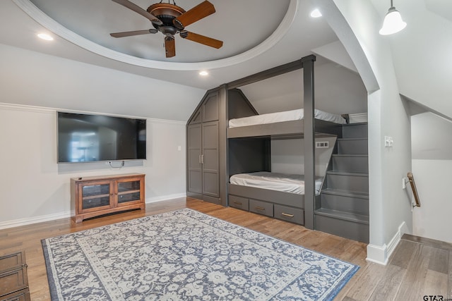 living room with light hardwood / wood-style floors, ceiling fan, and lofted ceiling