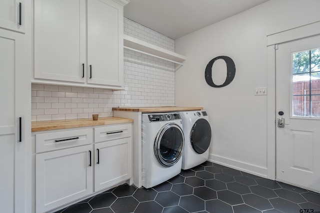 washroom featuring cabinets, separate washer and dryer, and dark tile patterned floors