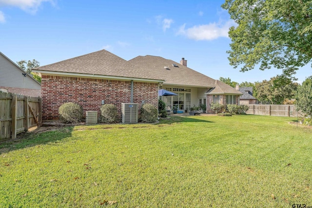 back of property featuring a lawn and cooling unit