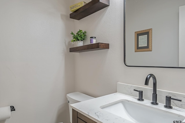 bathroom featuring vanity and toilet