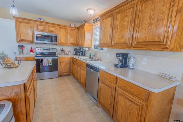 kitchen featuring decorative light fixtures, stainless steel appliances, and sink