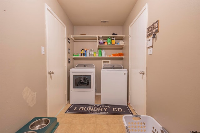 laundry area featuring light tile patterned floors and washing machine and clothes dryer