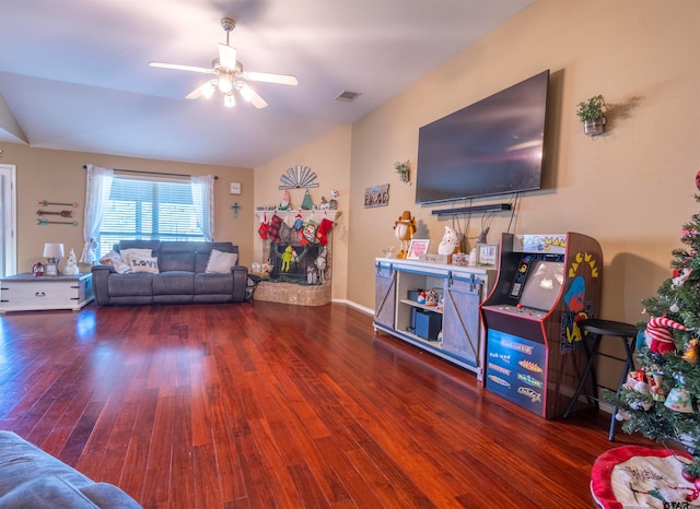 living room featuring dark hardwood / wood-style floors, vaulted ceiling, and ceiling fan