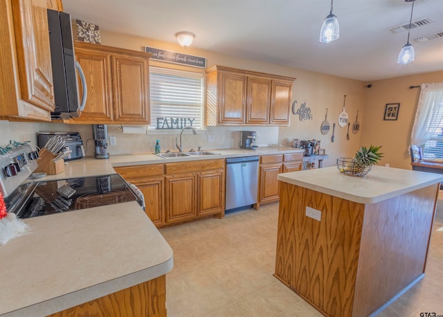 kitchen featuring sink, a kitchen island, stainless steel appliances, and decorative light fixtures