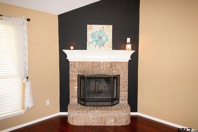 details featuring baseboards, wood finished floors, and a fireplace with raised hearth