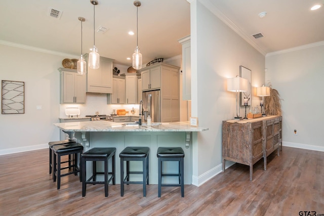 4523 Lone Oak Ln, Longview, TX 75605 - kitchen with stainless steel fridge with ice dispenser, ornamental molding, light wood finished floors, a peninsula, and a breakfast bar area