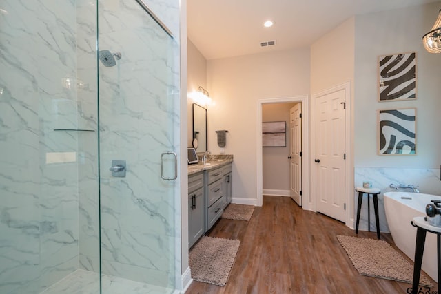 4523 Lone Oak Ln, Longview, TX 75605 - bathroom featuring a marble finish shower, vanity, a freestanding bath, and wood finished floors