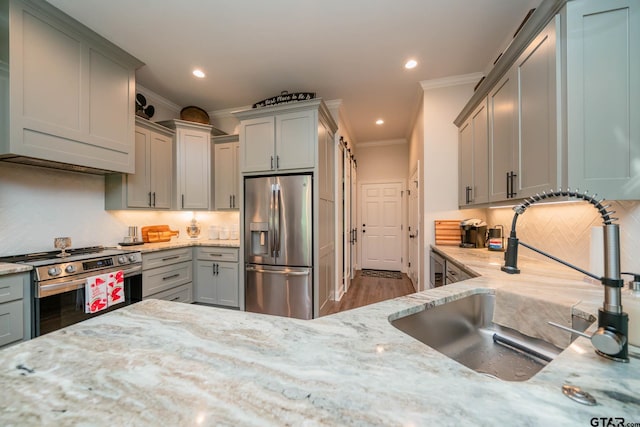 4523 Lone Oak Ln, Longview, TX 75605 - kitchen featuring appliances with stainless steel finishes, gray cabinetry, crown molding, light stone countertops, and decorative backsplash